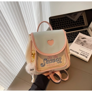 Close-up of mini backpack featuring heart cutout, clear pocket, and plush eye charm detail
