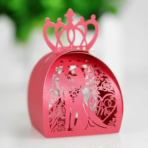 Macro shot of laser-cut red wedding favor box with crown and Mr & Mrs silhouette