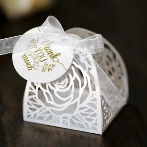 Macro di una scatola di confetti per matrimonio tagliata al laser con nastro e tag