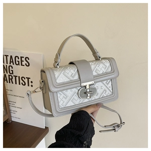 Detail of grey geometric jacquard small square bag with silver metal twist lock