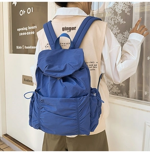 Vue détaillée du sac à dos bleu en nylon imperméable avec poches à cordon et fermeture à rabat