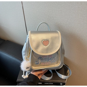 Detail of silver backpack with pink heart cutout and colorful letter embroidery