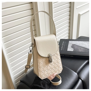 Detail of cream crossbody bag featuring woven texture and silver twist lock closure