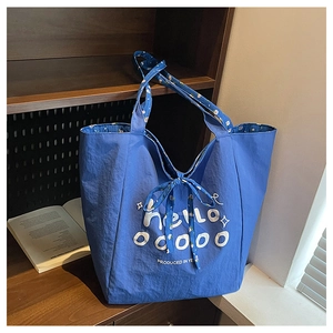Detail of blue canvas tote bag featuring floral lining accents and a small bow decoration