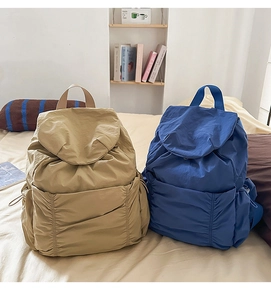 Vue détaillée des sacs à dos en nylon kaki et bleu avec poches à cordon et rabat supérieur