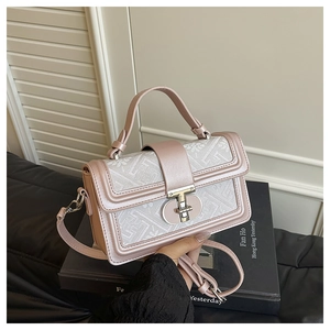 Detail of pink leather and geometric jacquard fabric shoulder bag with T-shaped metal lock