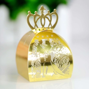 Detail of laser cut gold wedding favor box with Mr & Mrs crown and floral pattern