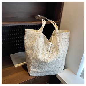 Close-up of seersucker tote bag with pink floral print and a delicate drawstring bow