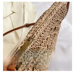 Detail showing smooth bronze metal zipper and fine woven texture of the shoulder bag
