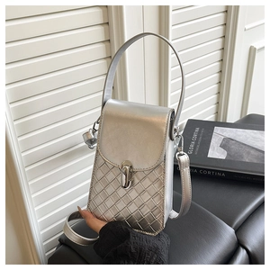 Detail of silver metallic mini bag featuring quilted texture and metal twist lock closure