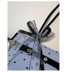 Detailed macro view of the striped fabric bag featuring heart prints and a polka dot bow