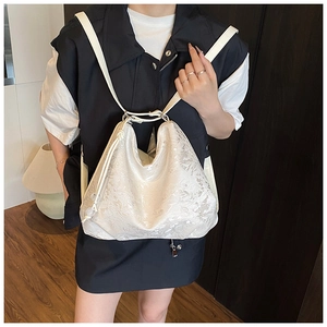 Detail of white embroidered lace texture on a stylish versatile crossbody bag for women