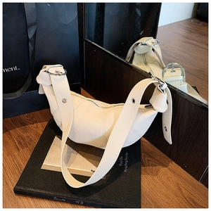 Close-up of cream leather croissant bag showing fine texture and silver hardware details