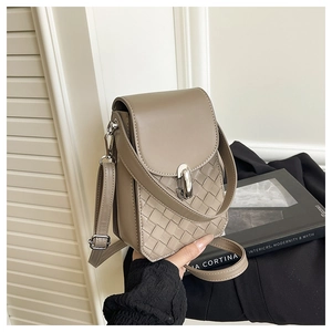 Detail view of woven leather small square bag with adjustable strap and silver hardware