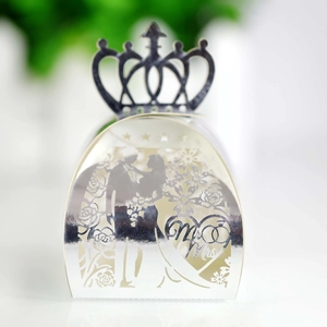 Macro view of silver laser-cut wedding candy box with Mr & Mrs and crown detail