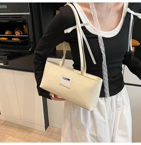 Detail of cream white rectangular shoulder bag with CLEA❤K patch and smooth PU leather