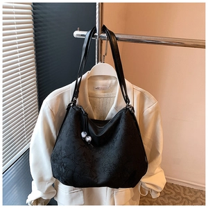 Detail of black embroidered tote bag with satin texture and beaded drawstring details