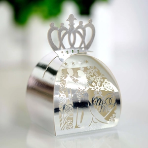 Macro view of silver laser-cut wedding favor box with crown and Mr & Mrs heart pattern