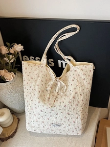 Floral cotton tote bag with bow detail and Magic Pocket label in a cozy setting
