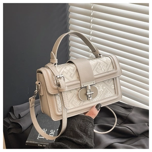 Detail of vintage square bag showing floral embroidery and silver metal twist lock