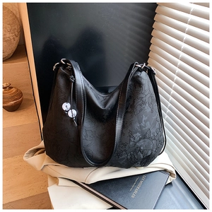 Detail view of black floral jacquard hobo bag with marble bead and smooth shoulder strap