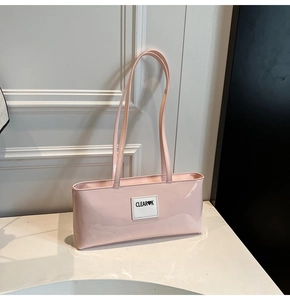 Detailed shot of pink faux leather shoulder bag with CLEAR-K brand logo patch on front