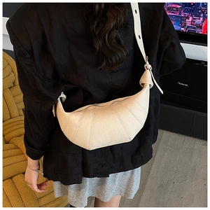Detailed back view of a beige croissant bag with knotted details and wide shoulder strap
