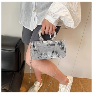 Detail of grey marble texture crossbody bag with silver metal handle and chain strap