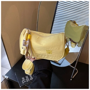Close-up of yellow pillow bag featuring pleated fabric and CHUU 'D♥N embroidered logo