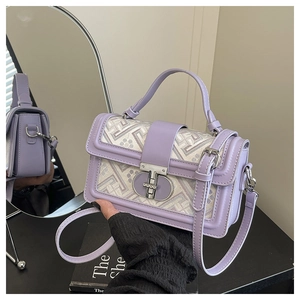 Detail of purple crossbody bag with geometric fabric inlay and silver metal buckle