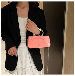 Pink marble acrylic mini box bag with silver ring handle and chain strap shown with outfit