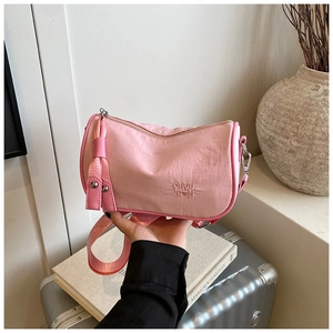 Detailed close-up of a pink nylon barrel bag featuring rippled texture and logo