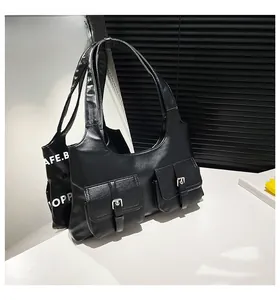 Détail du sac sous l'aisselle en similicuir noir avec deux poches et boucles argentées