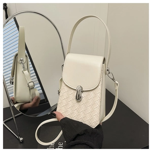 Detailed view of cream crossbody bag featuring woven texture and silver metal lock closure