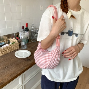 Pink and white gingham crescent hobo bag shown being worn in a casual lifestyle setting