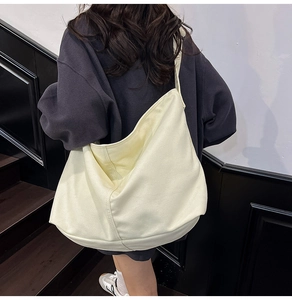Vista trasera de una modelo con un gran bolso tote de lona crema en un ambiente moderno