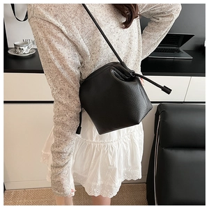 Vue macro détaillée de la texture en cuir noir grainé sur ce sac seau élégant et moderne