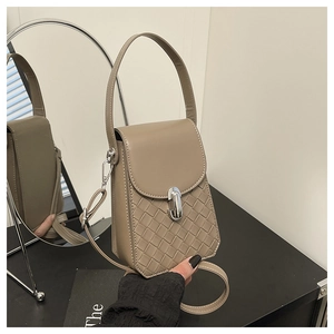 Detail of khaki crossbody bag featuring woven leather texture and silver clasp