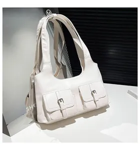 Détail du sac à bandoulière blanc en similicuir avec deux poches avant à boucles