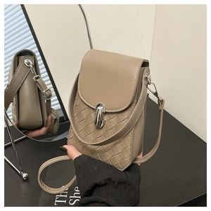 Detail of tan woven crossbody mini bag with silver clasp and adjustable strap