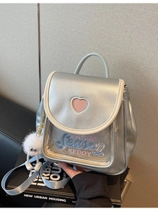Silver metallic mini backpack with heart window and cute plush monster keychain accessory