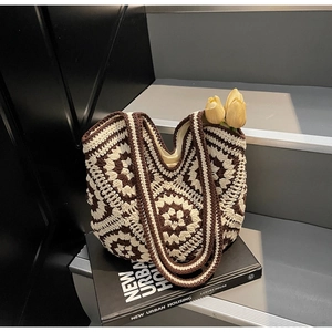 Détail de la texture au crochet du sac fourre-tout en tricot floral sur fond de livre