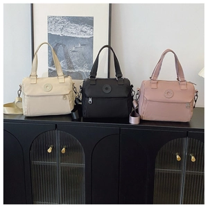 Detailed view of nylon crossbody bags in cream, black, and pink with adjustable straps