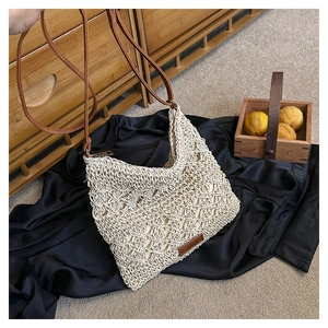 Detail of hand-woven beige crossbody bag featuring mesh texture and brown strap