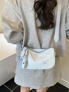 Minimalist light blue crossbody pillow bag with CHUU DON text and wide strap