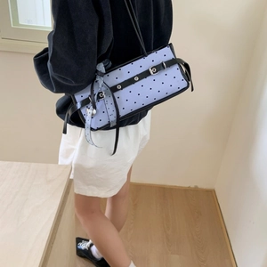 Detail of blue heart patterned baguette bag with a decorative silk scarf and silver buckles