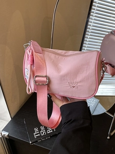 Pink nylon crossbody pillow bag with woven strap and CHUU heart embroidery