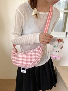 Pink plaid canvas crescent crossbody bag with stripe strap and plush bunny charm