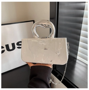 Detail of white marble acrylic handbag with silver metallic handle and chain strap