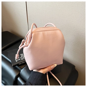 Détail de la texture en cuir synthétique grainé rose sur un petit sac seau chic